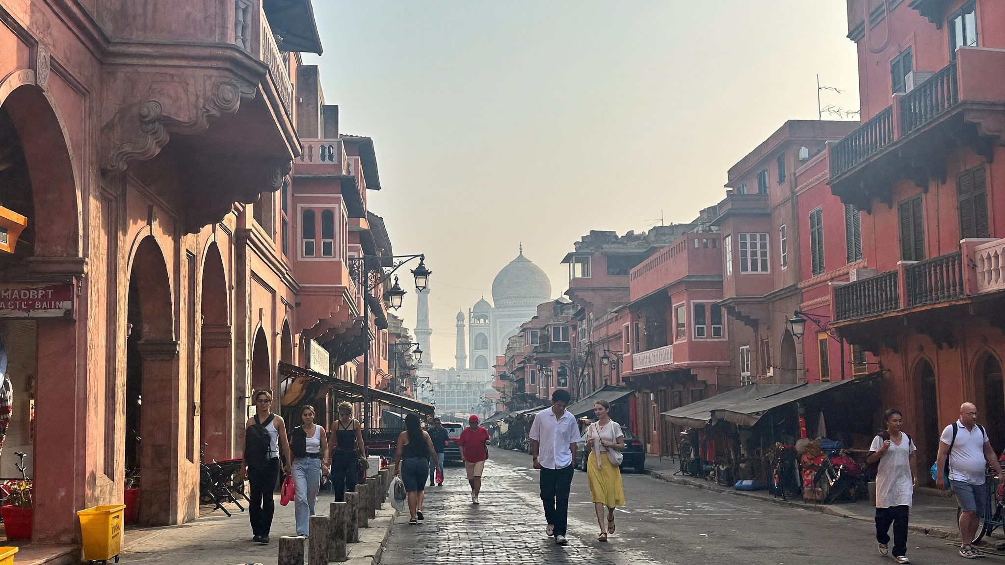 जयपुर की सुबह की गली में चलते यात्री, हल्की धूप में